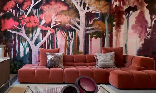 Photo d'un salon avec un papier peint dans les tons rouges et orange représentant une forêt