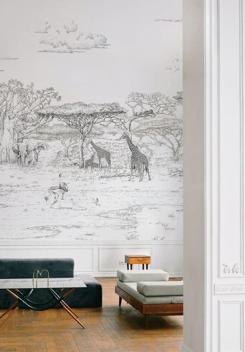 Salon avec un Papier peint panoramique en blanc et noir représentant des animaux buvant au bord d'un marécage avec des plaines et des montagnes en arrière-plan